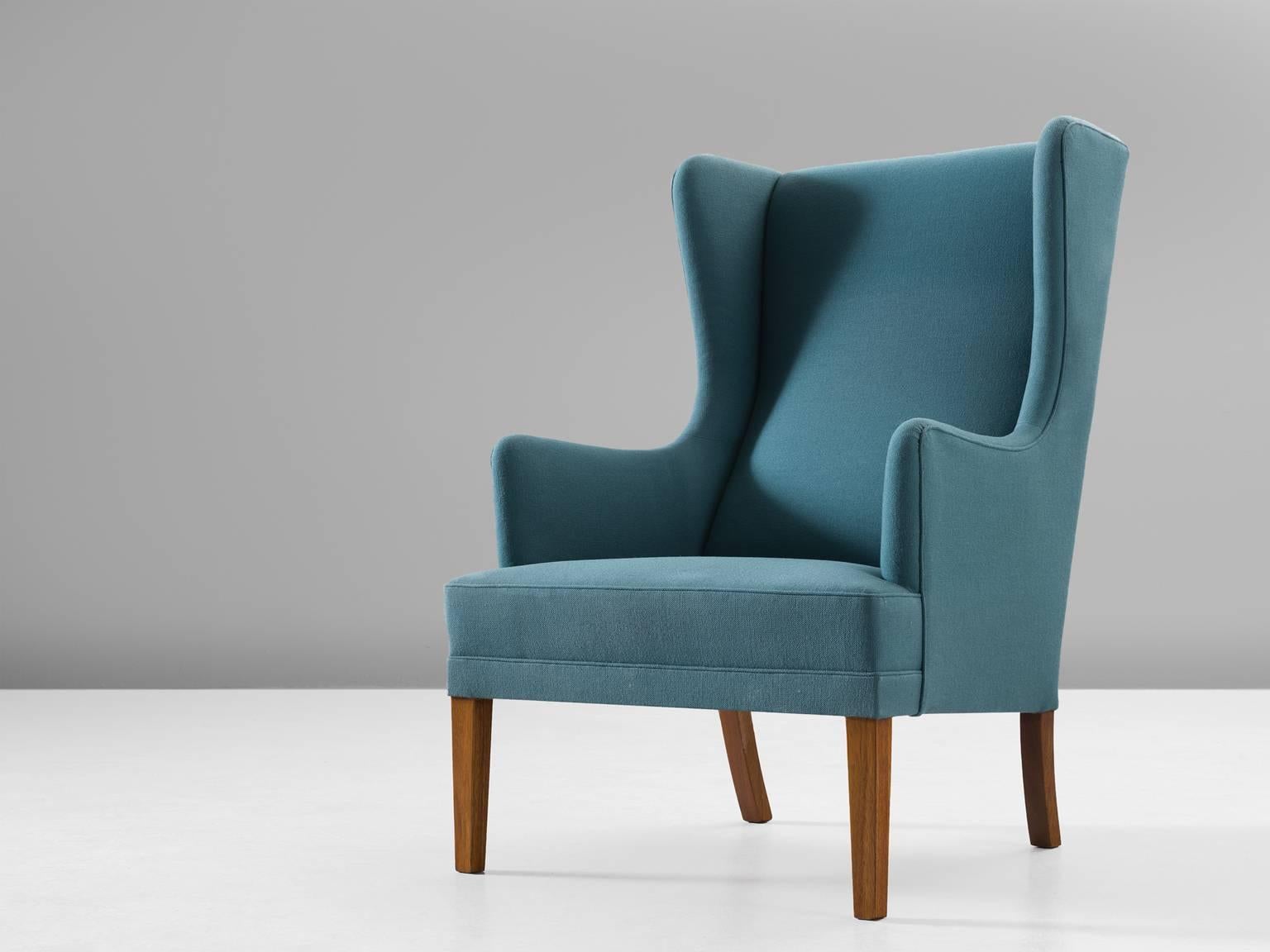 Armchair, fabric, oak, Denmark, 1950s.

This archetypical wingback chair of the 1950s is both extremely comfortable and pleasing to the eyes. Soft edges, tilted shapes and muted colors make this a truly mid-modern armchair from Denmark. The matching