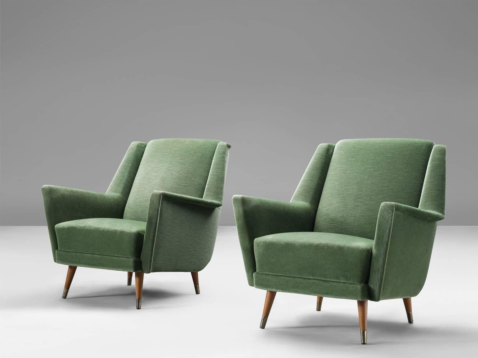 Two armchairs, green velvet and wood, Italy, 1960s.

These two medium-sized green lounge chairs feature small brass and wood feet with a comfortable seat. The seat shows both organic and geometric shapes. The armrests point slight upwards for