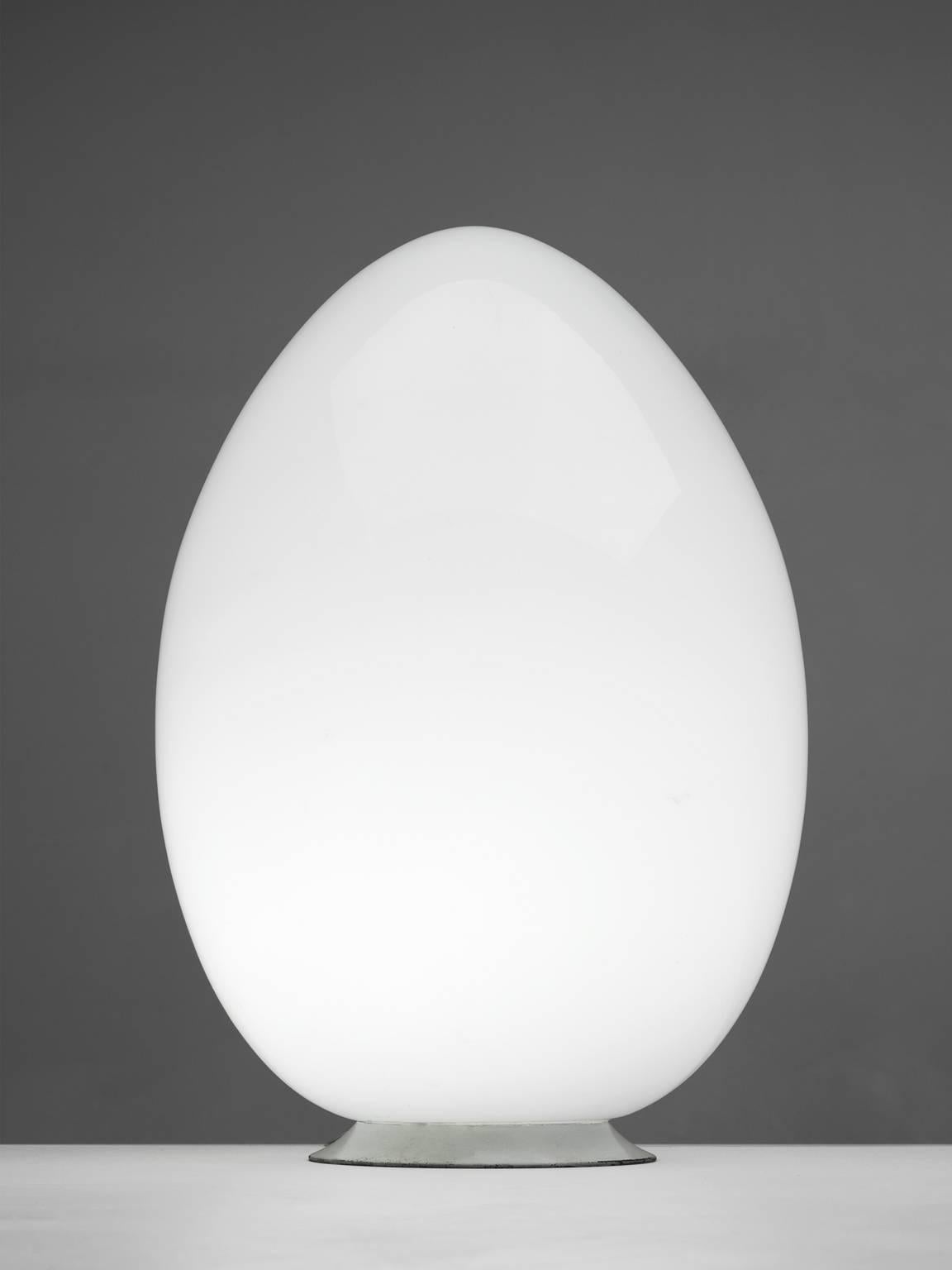 Egg shaped lamp, opaline glass, metal, Italy, 1970s.

This floor or table lamp in Murano glass has an oval form resembling an egg. The opaline white glass gives off a nebulous light partition. The lamp is both playful and functional at the same