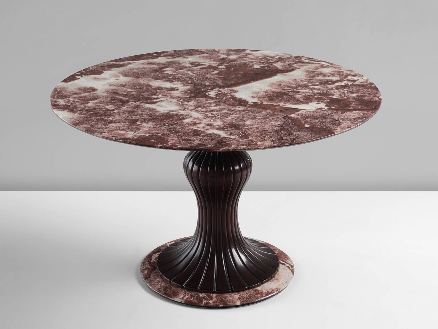 Dining table, in marble and wood by Osvaldo Borsani, Italy, 1950s. 

This distinctive center table is made in the 1950s and holds a wooden decorated shaft. The main feature of this table is the deep purple to red marble thin marble top. The veins