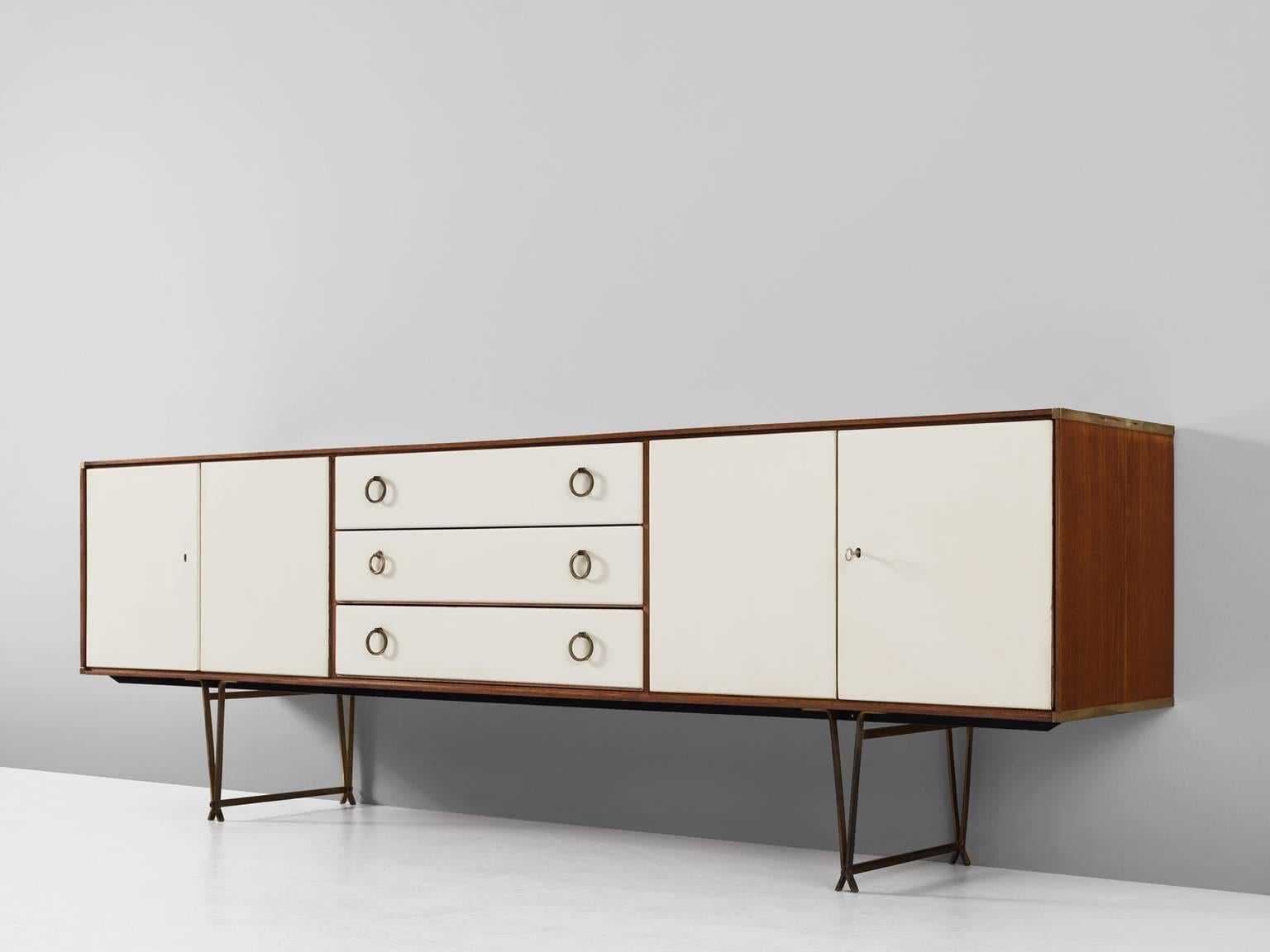 Sideboard, in teak, wood, brass and metal, for Fristho, the Netherlands, 1960s. 

Elegant sideboard in teak with white lacquered front and brass details. This cabinet shows very refined metal legs, which create a floating character. The outside of