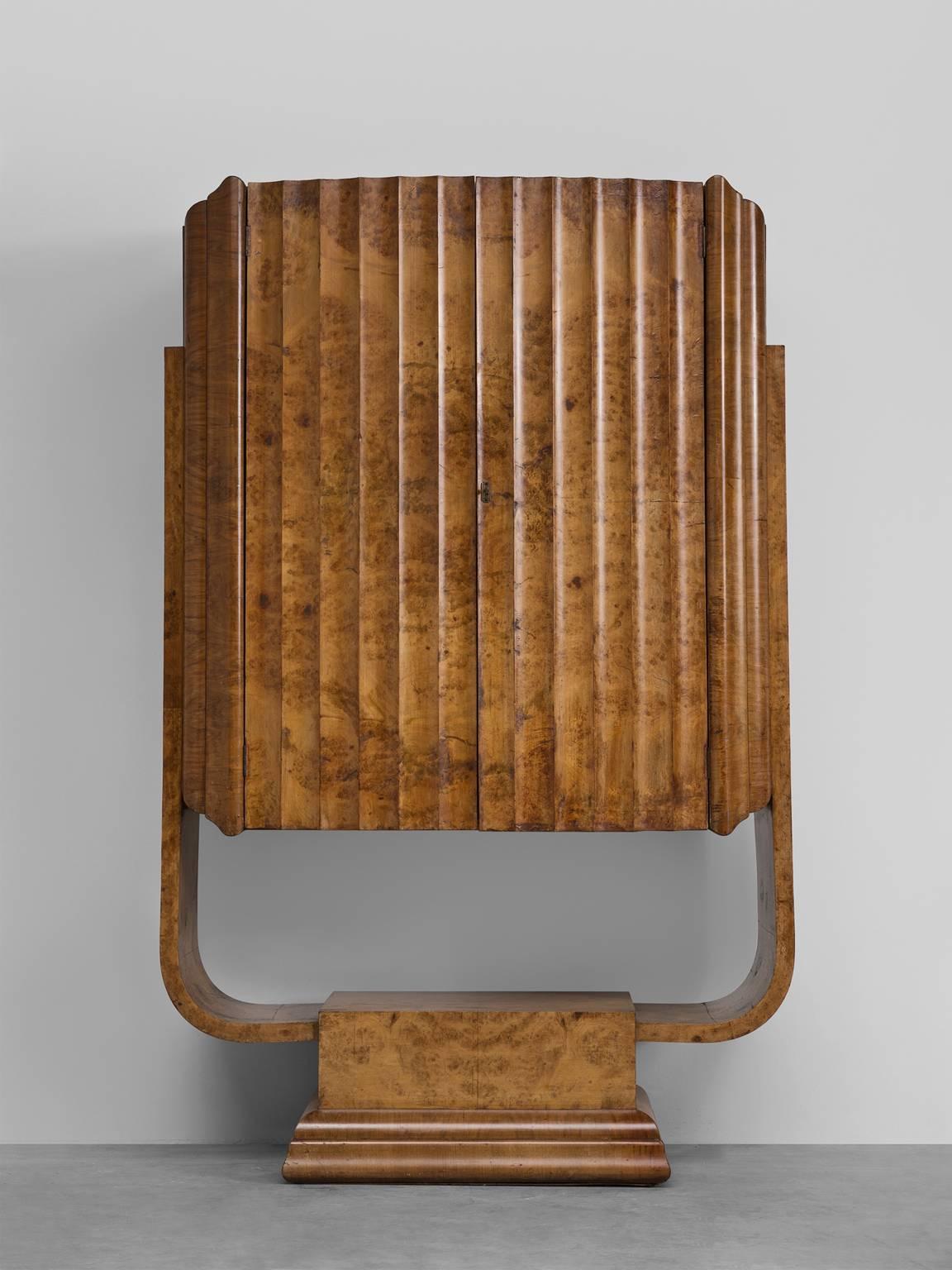 Cabinet, walnut burl, Italy, 1960s.

This sensuous cabinet is executed in walnut burl. The cabinet features a sculptural base from which two curved burl wood arms stretch upwards. The cabinet has two waved burl doors. The waving of the burl wood