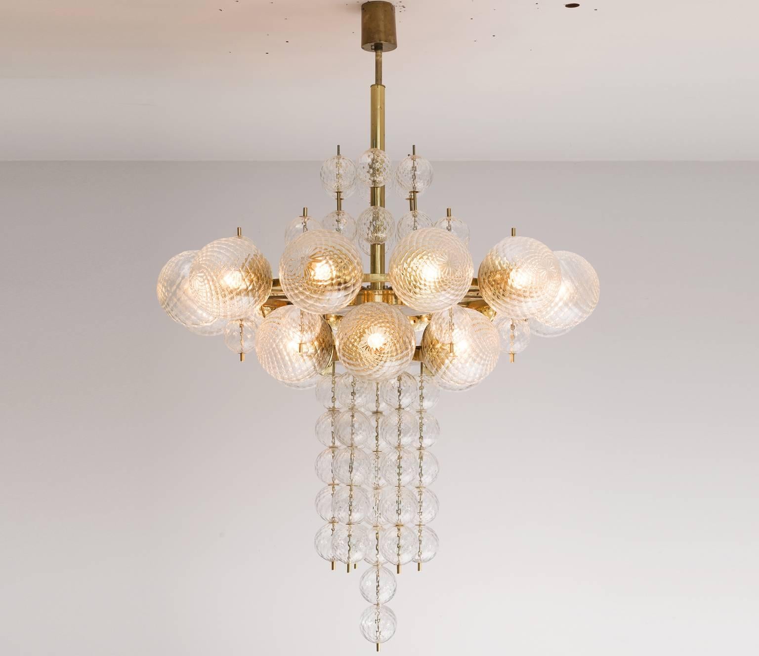 Chandelier in glass and brass, Europe, 1970s.

Large chandelier in structured glass and brass. The structured glass brings a stunning light partition. The patinated brass creates a warm atmosphere. Four items available.

Price listed per item