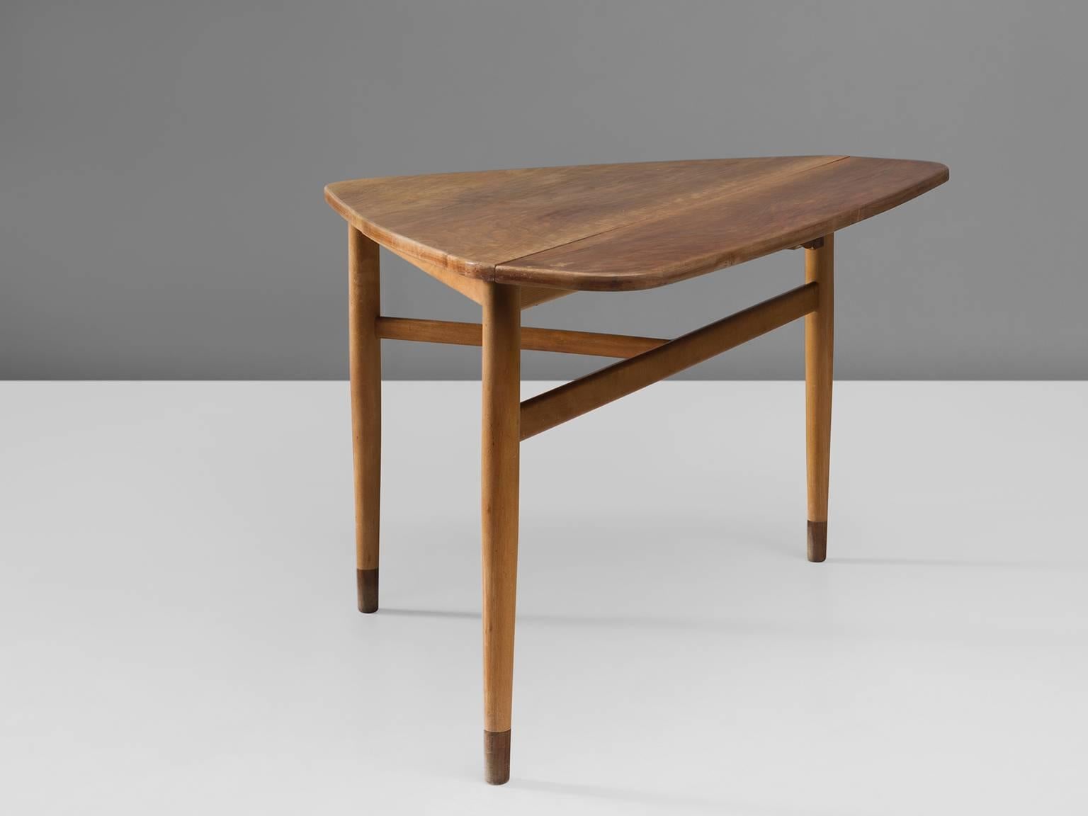 Cocktail table, walnut, teak and beech, attributed to Arne Vodder, Denmark 1950s. 

This triangular coffee table with legs of beech and shoes of teak. The table has three legs that are connected with beech slats that form a T. The table is unique