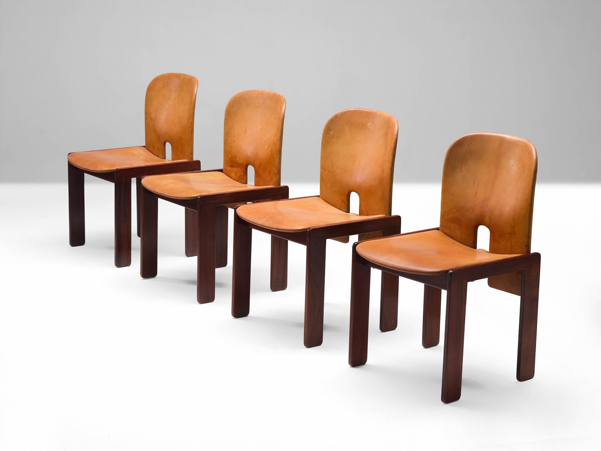 Set of four chairs model 121, in rosewood and cognac leather, by Afra & Tobia Scarpa for Cassina, Italy, 1965.
 
Set of four chairs by Italian designer couple Tobia and Afra Scarpa. These chairs have a cubic appearance. The base consist of four