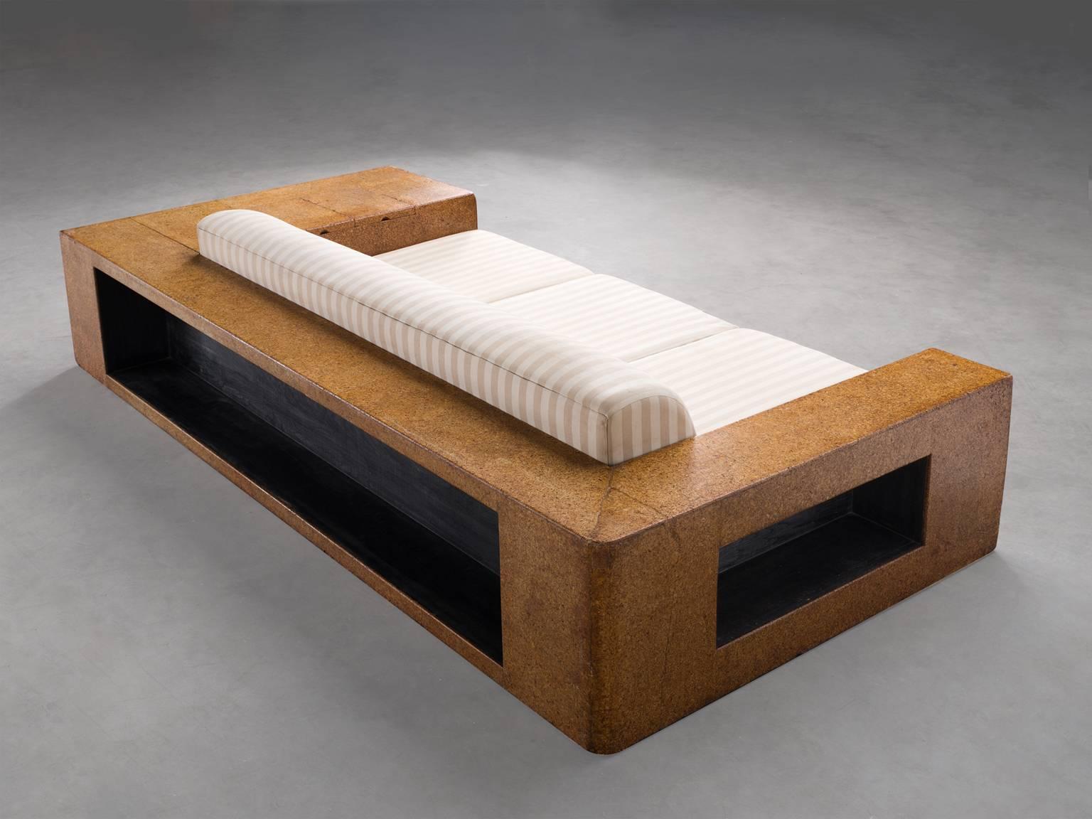Sofa, enameled wood, cork, upholstery, New York, 1930s.

This sofa is robust and warm. The materials used, cork, fabric and enameled wood all create a comforting environment. The design of the sofa is original in the most literal sense: it was