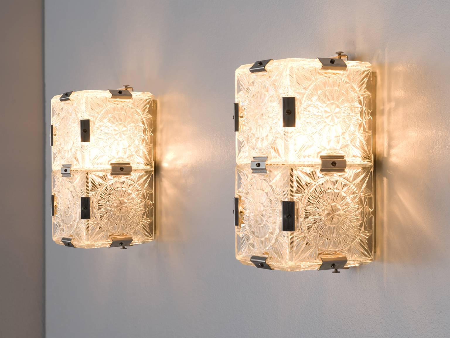 Wall lights, brass and structured glass, Europe, 1930s.

These geometric sturdy wall lights give off a warm light partition thanks to their thick, high-quality glass. The lights feature a double, symmetrical lay-out with abstract patterns. Although