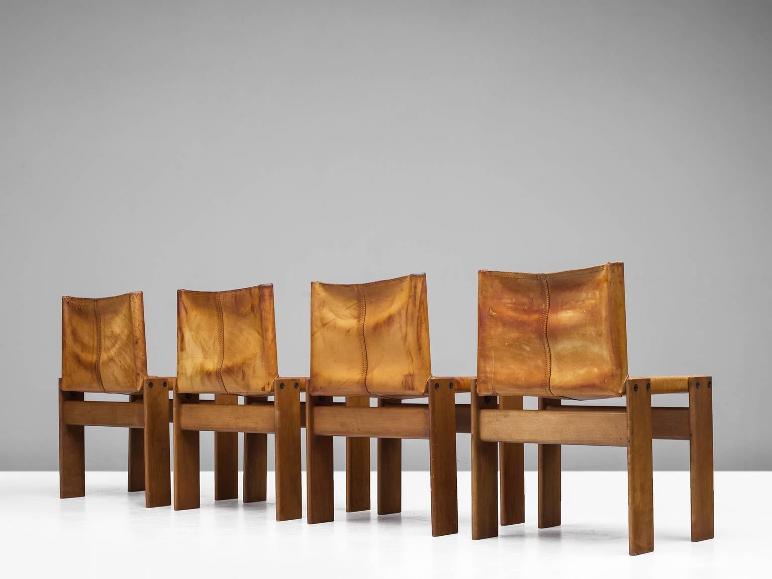Dining chairs by Arfa & Tobia Scarpa, walnut and cognac leather, Italy, 1974.

These four chairs are strong and sturdy in their design. The wonderfully warm patinated leather is very wel suited to the dark, aged oak. Interesting is the 'flat'