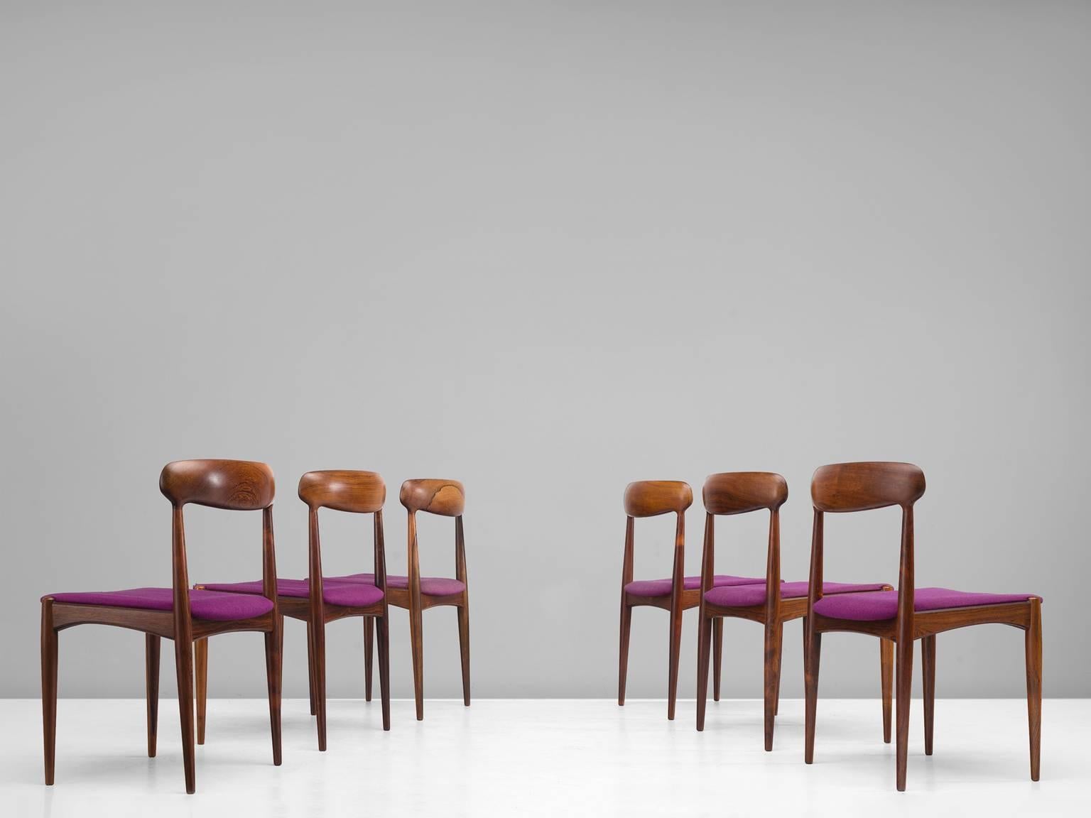 Dining room chairs, rosewood, purple fabric by Johannes Andersen and manufactured Uldum furniture factory, Denmark,1960s.

The restrained chic rosewood dining chairs are soft and warm in their appearance. The backrest is slightly tilted and
