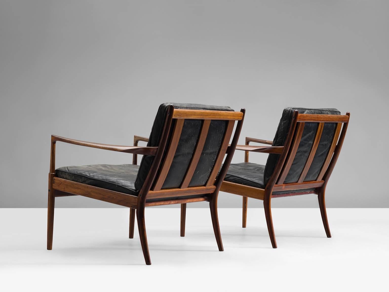 Ib Kofod-Larsen rosewood 'Samsö' easy chair, circa 1960–1969.

These gorgeous black leather and rosewood Danish modern lounge chairs were designed by Ib Kofod-Larsen (1921-2003). They feature rosewood frames and amazingly black leather. Danish
