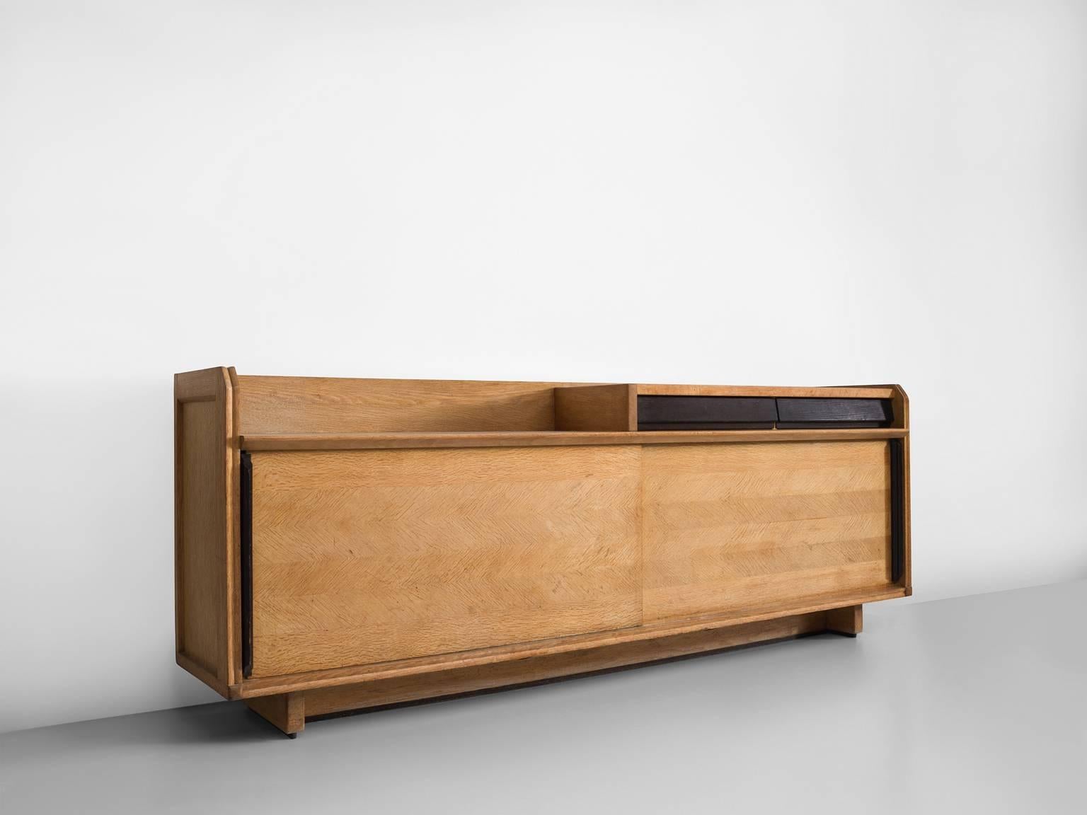 Credenza, in oak, metal and ceramic, by Robert Guillerme et Jacques Chambron for Votre Maison, France, 1960s.

This cabinet is designed by the French designer duo Guillerme and Chambron. The sideboard is characterised by the oakwood inlay patterns