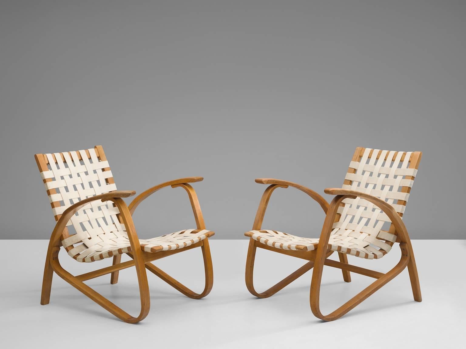 Pair of lounge chairs, in beech and canvas, by Jan Vanek for UP Zavodny, Czech Republic, 1930s. 

Stunning pair of dynamic armchairs designed by Czech architect Jan Vanek, who was a contemporary of Jindrich Halabala. These chairs are upholstered