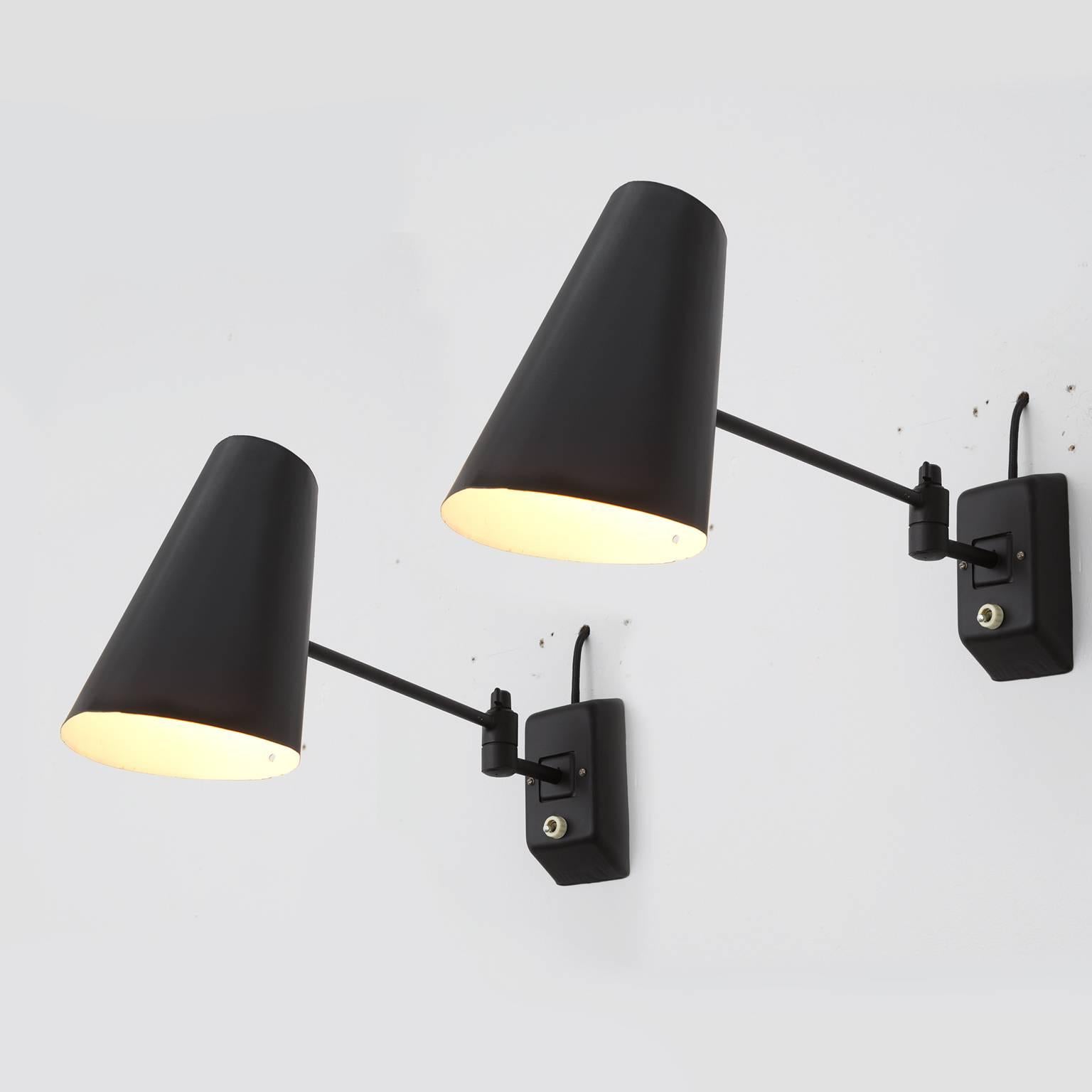 Set of wall lights in black metal, Europe, 1960s.

The tapered shade of thin metal sheet was placed onto a thin stem. It can be directed, the turning element is a nice detail, the sconces can be used in a hall way or as bedside lamps. The white