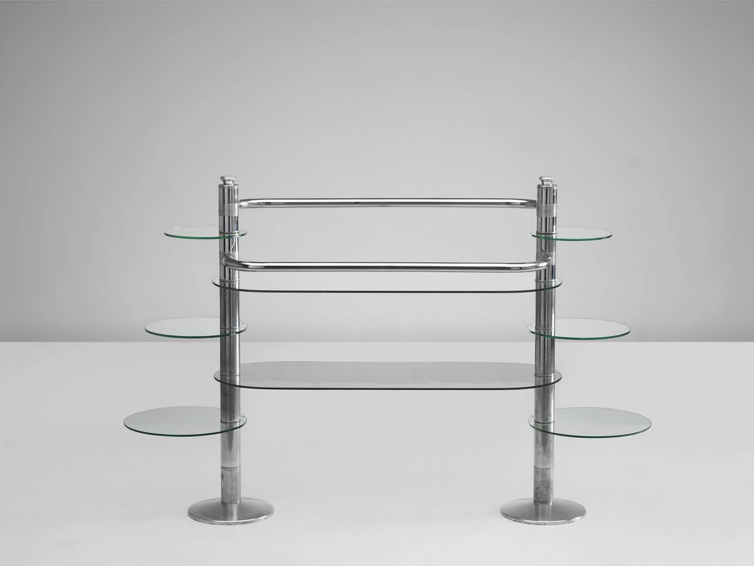 Freestanding display unit in chrome and glass, Italy, 1980s.

This playful display unit has two large glass shelfs and six small round shelfs, three on each side. The small shelfs on the sides differ in size and swivel, which makes it practical as