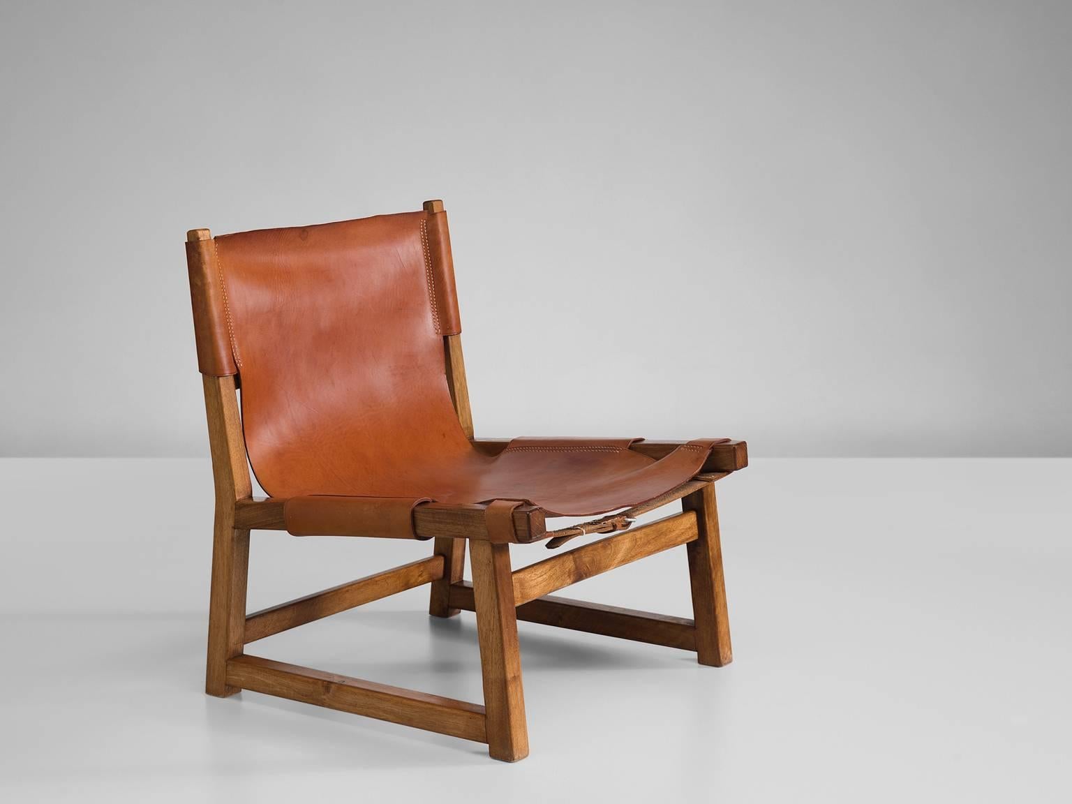 Hunting chair, oak and leather, 1950s, Denmark

This strong and sturdy low lounge chair is unmistakably Danish. The design of this hunting chair, with it leather loosely attached to the frame by means of straps that go around the frame and that