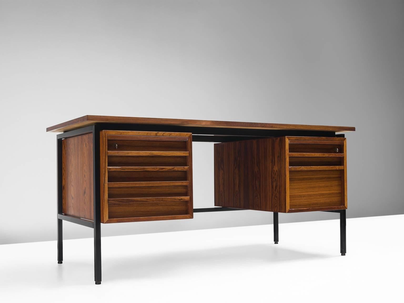 Executive desk, in rosewood and metal, Denmark, 1960s.

Freestanding desk in rosewood and black metal. This functional, Minimalist and elegant writing desk is designed with high attention to detail. The cylindrical legs provide a floating