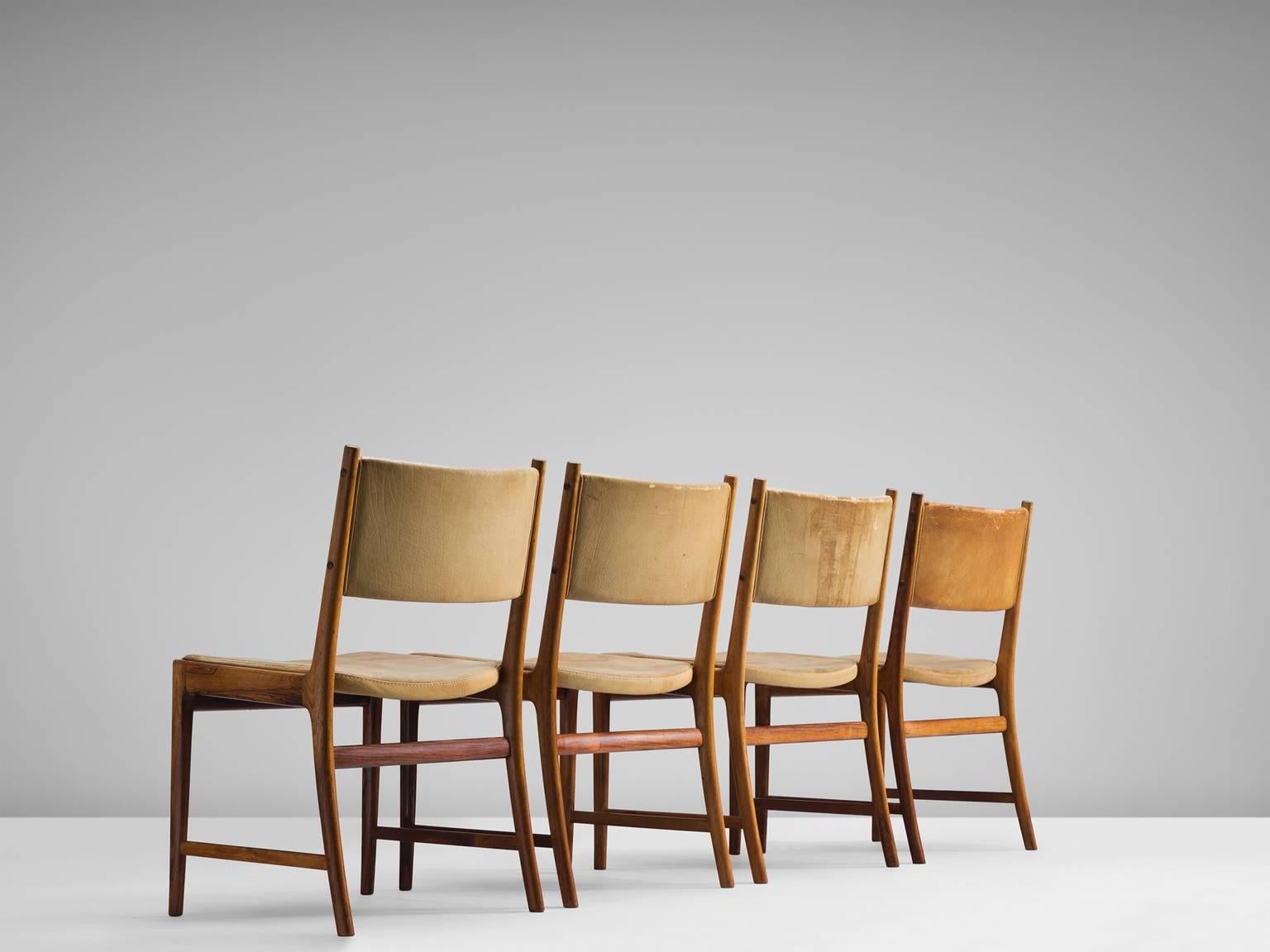 Set of four dining chairs in wood and cognac leather, by Kai Lyngfeldt Larsen, Denmark, 1960s.

These comfortable dining chairs show wonderful craftsmanship. The original pale cognac leather upholstery has aged in a beautiful way. The angular frame