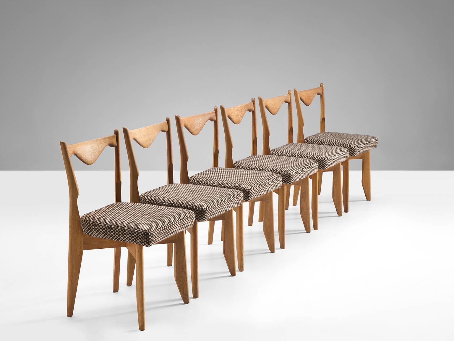 Set of six dining chairs, in oak and papercord, by Guillerme & Chambron, France, 1960s.

Set of six elegant dining chairs in solid oak by Guillerme and Chambron. These chairs show the characteristic frame of this French designer duo. Tapered legs