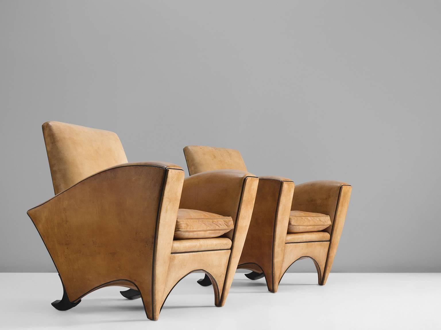Cognac club chairs, in cognac leather with black leather piping and wood, Europe, 1970s.

This set of club chairs in cognac leather with black piping have very original and strong appearances. The sturdy design features interesting curved feet that
