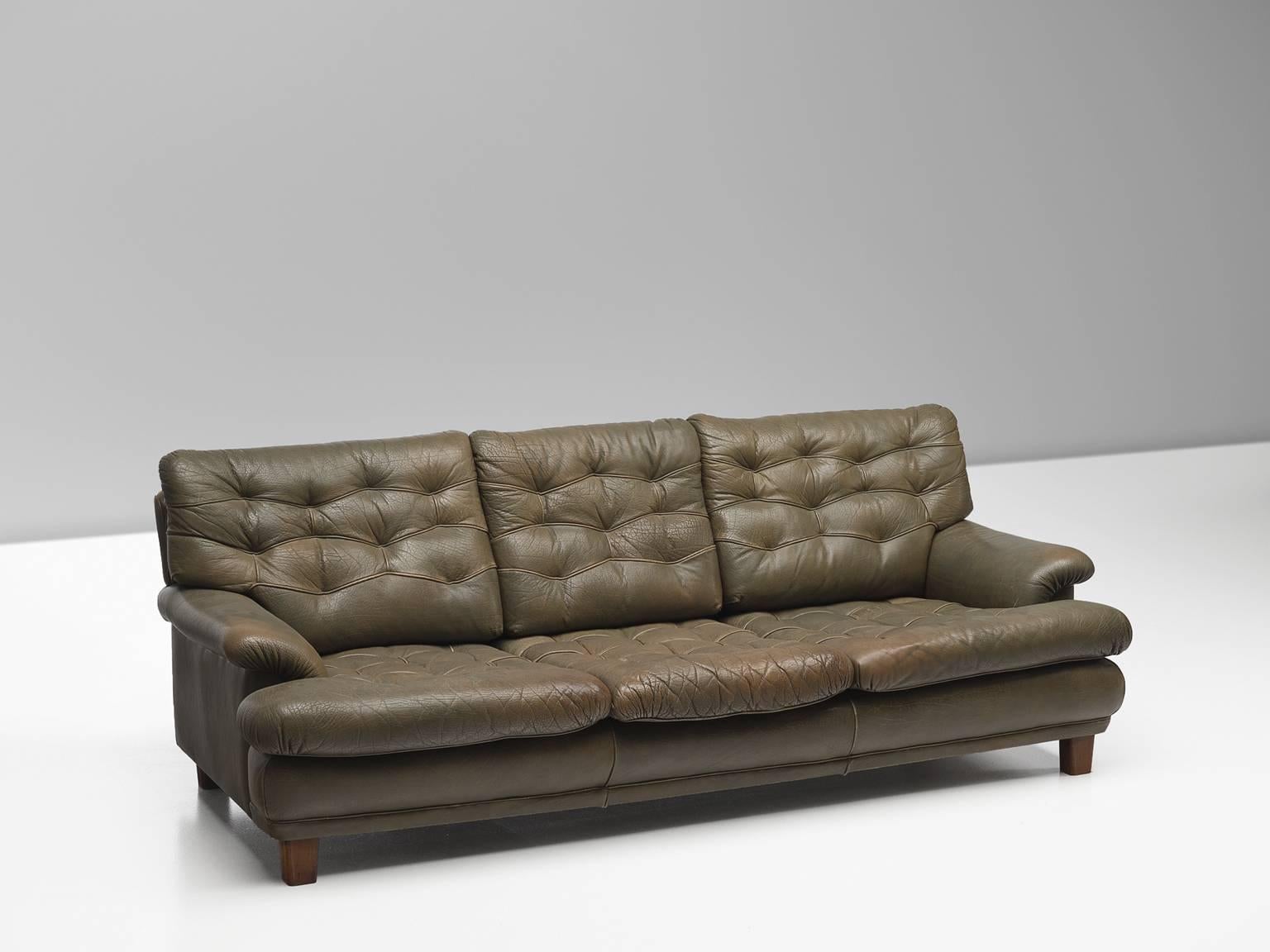 Sofa, in olive green leather and wood, by Arne Norell, Sweden, circa 1964. 

Three-seat sofa by Arne Norell. This sofa is refined, modern and with a robust touch. A true Swedish and Norell design. The sofa is made of brown leather with four cubic