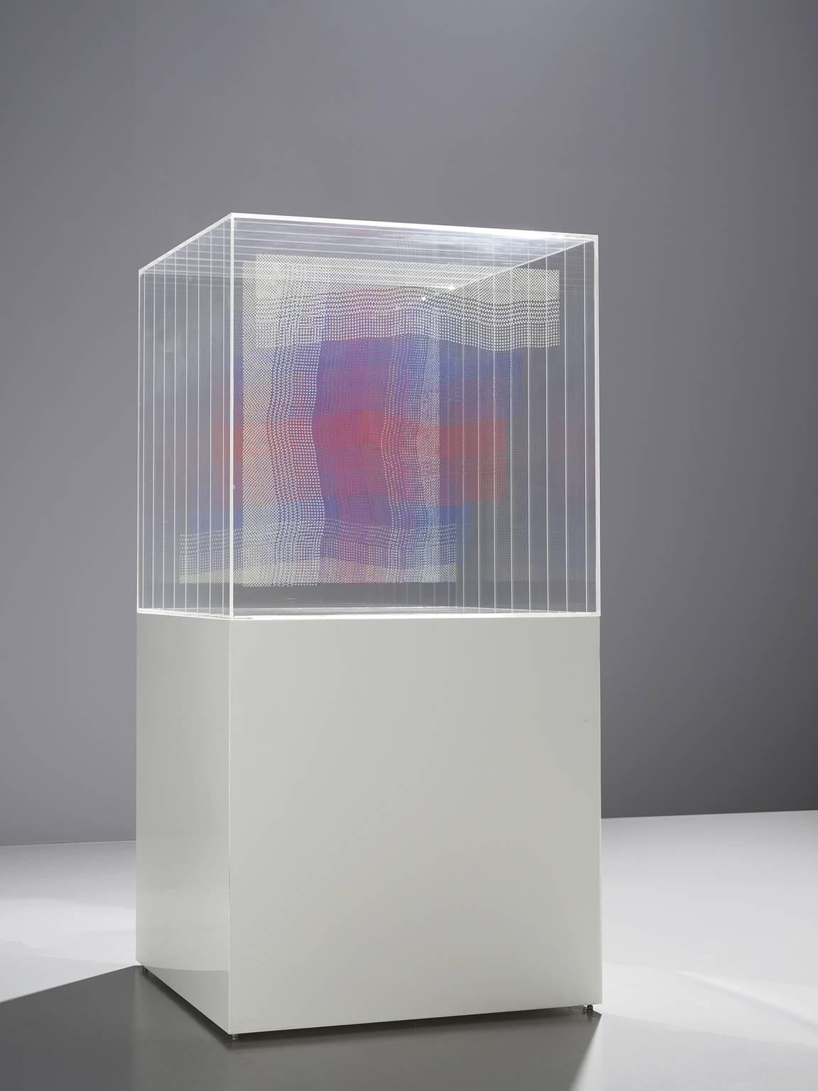Artwork, wooden pedestal with perspex cube and layers in blue white and red by Maria Westra, The Netherlands, 1985.

This cubistic abstract piece is derived from Westra's interest in monumental fabrics and weaving. Westra's main interest lies in the