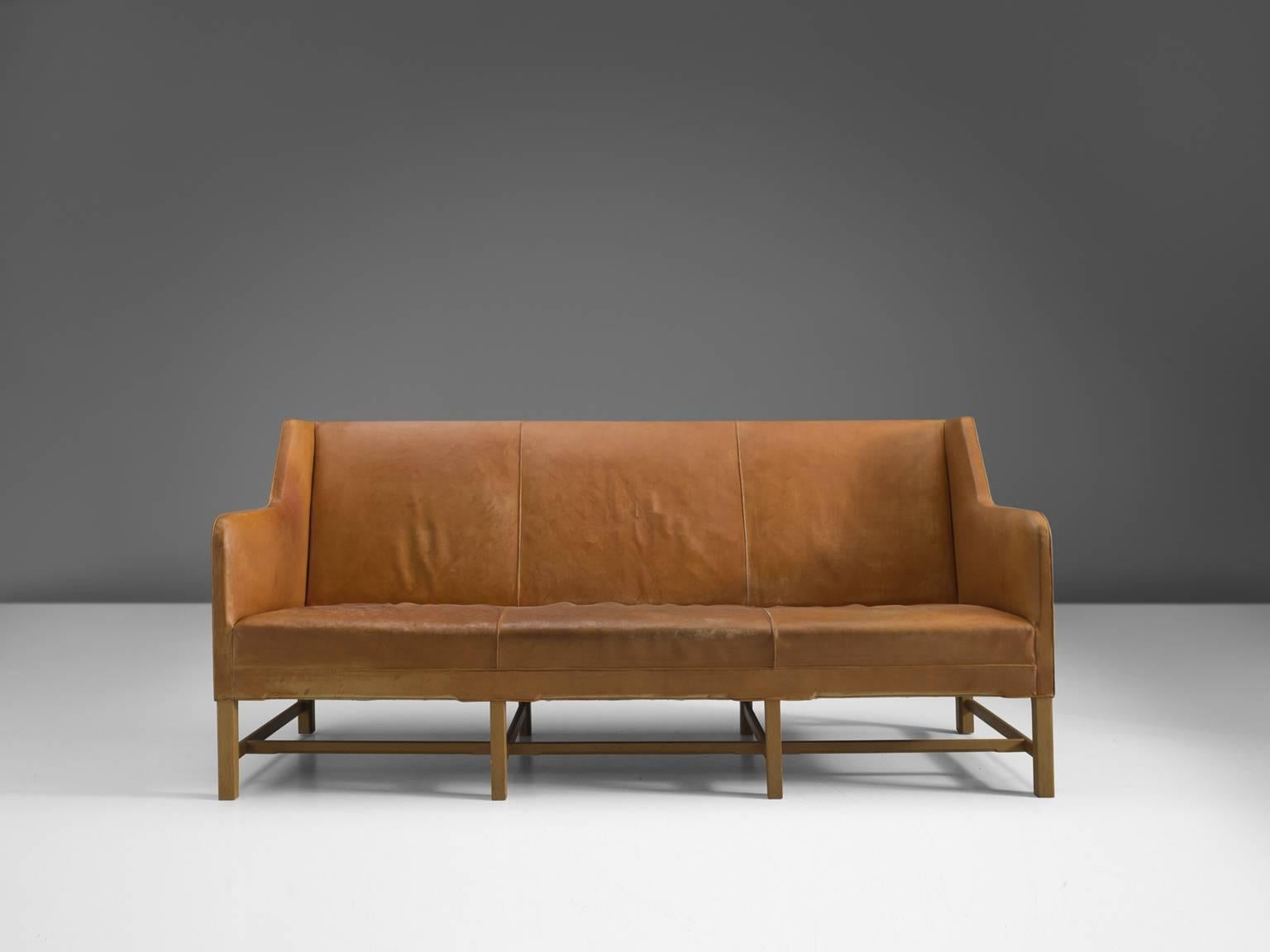 Sofa model 5011, in leather and oak, by Kaare Klint for Rud Rasmussen, Denmark 1935. 

Classic and elegant Scandinavian three-seat sofa by Kaare Klint. This model was designed in 1935. The base consists of eight legs in oak with cross-connections,