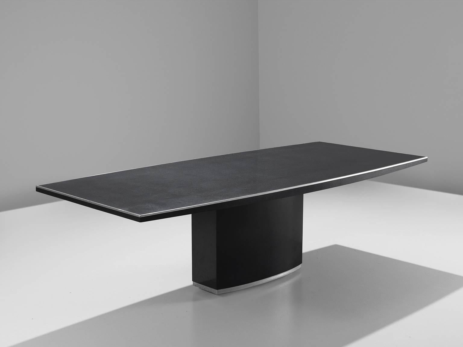 Dining table, in stone and steel, Italy, 1970s. 

Dining table, solid black stone top with steel edges. The pedestal base flutes and straight top result in an architectural design that is both stately and modern. 
This stateliness is reflected in