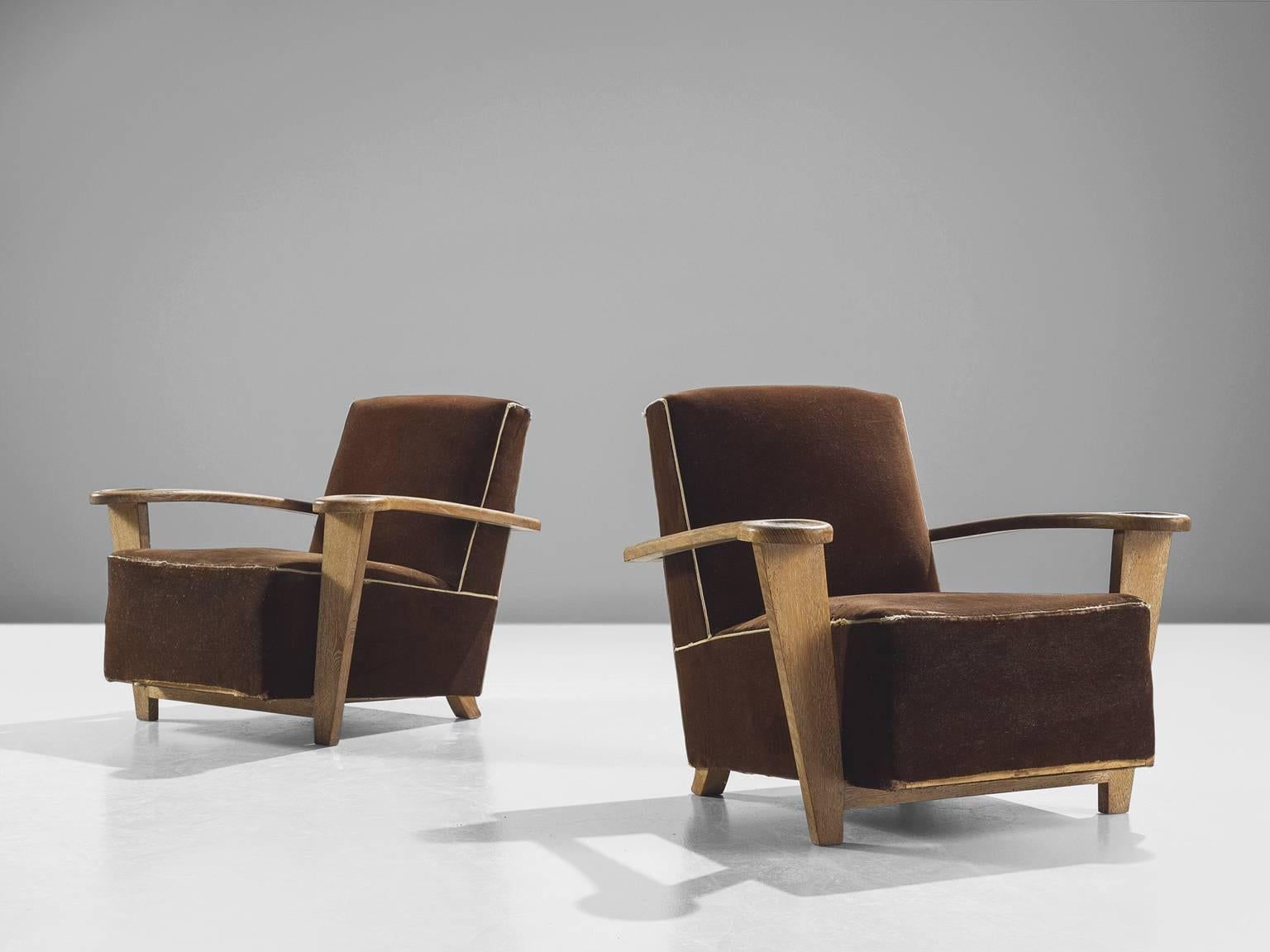 Pair of lounge chairs, oak and brown fabric, Belgium, 1940s.

This pair of rare grand armchairs is by the Belgian De Coene brothers. The chairs feature comfortable, thick cushions that are upholstered in a dark brown velvet. The velvet is rimmed