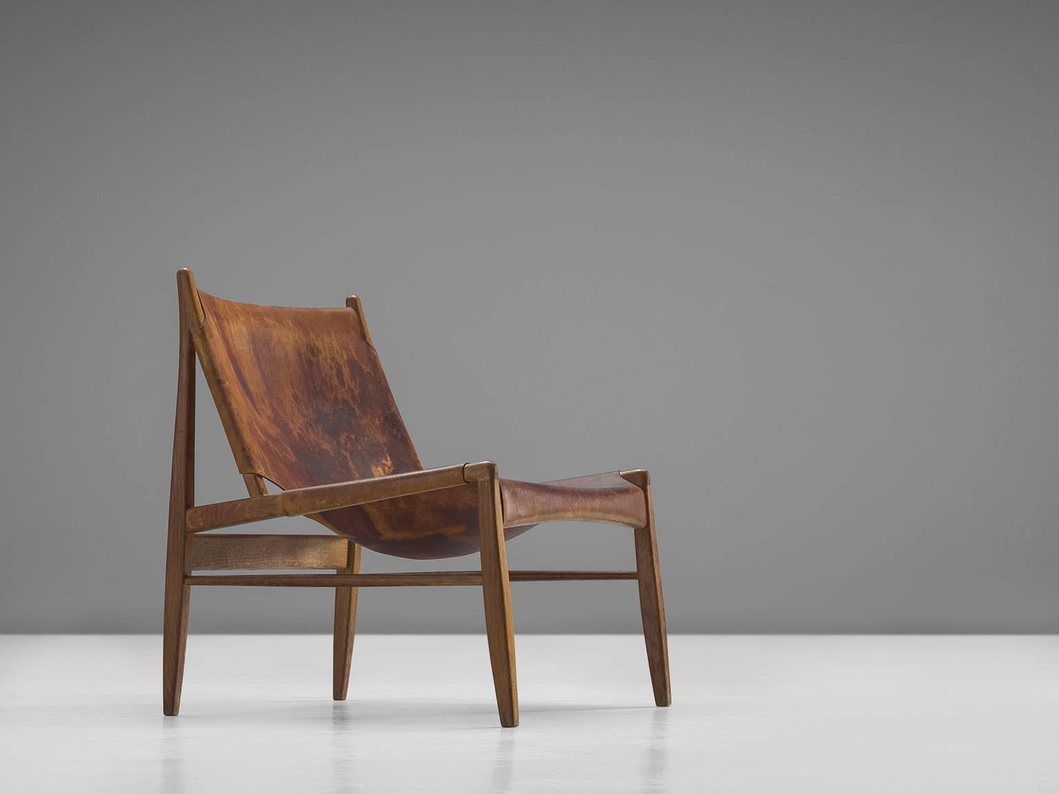 'Chimney' chair, oak and patinated cognac leather by Franz Xaver Lutz for WK Verband, Germany, 1958, Germany. 

This early Chimney chair by Franz Xaver Lutz bears strong resemblances to Spanish and Scandinavian hunting chairs. The design is aptly