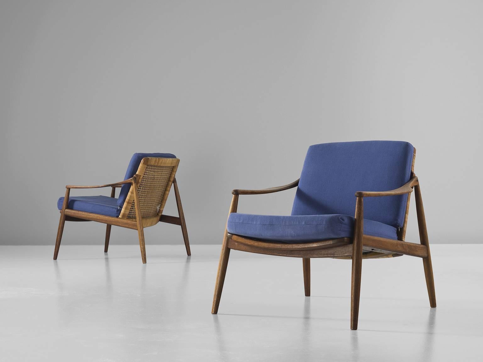 Armchairs, blue fabric, teak and rattan, Hartmut Lohmeyer, manufactured by Wilkhahn, Germany, 1956.

The lounge low armchairs are sensuous and organically shaped. They feature a slightly tilted back and are detailed with tapered legs. The softly