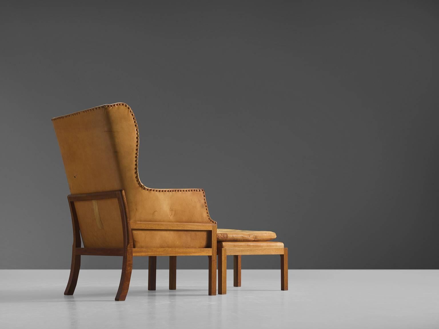 Wingback chair and ottoman model MK50, in mahogany and leather, by Mogens Koch for Rud Rasmussen, Denmark, 1936.

Elegant and comfortable armchair in mahogany and leather by Mogens Koch. This lounge chair was designed with high attention to