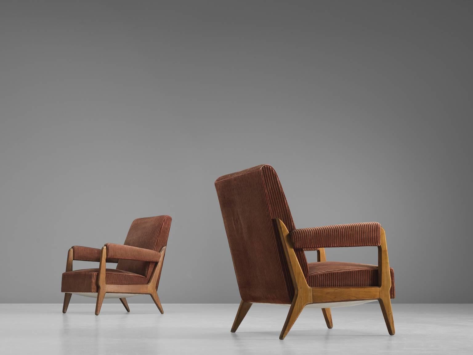 Lounge chairs, oak and fabric, France, 1950s

This set of rich, carved sculptural lounge chairs features a tilted back, upholstered thick armrests and tapered diagonal legs. The open space that exist within the armrests and in between the legs are