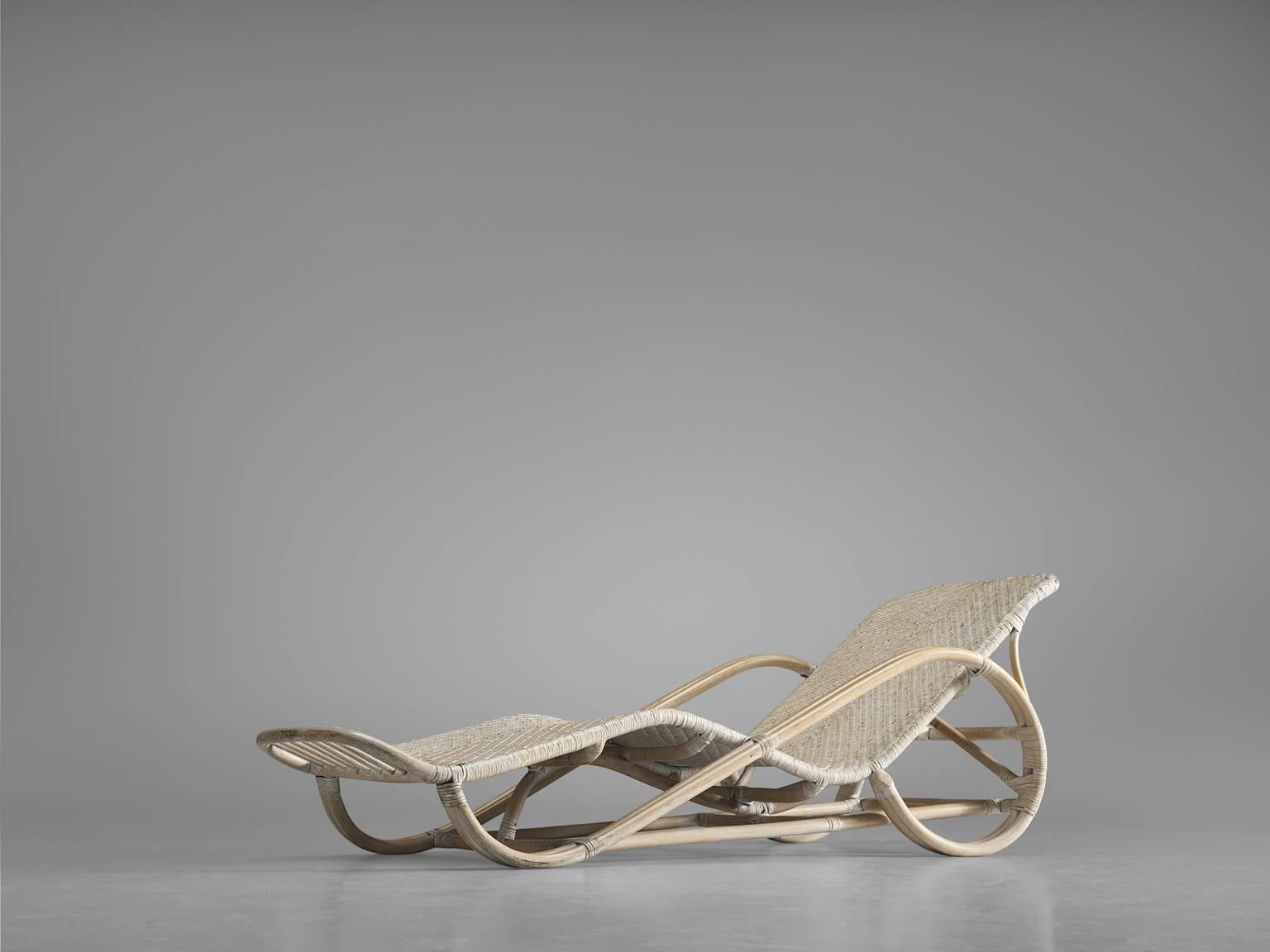 Daybed, ratan, Italy, 1950s.

This curveous daybed features a bent ratan frame and a woven, cane seat. The whole chaise longue is white washed, giving the chair a clean, modest appearance despite its theatrical forms. The daybed is made in the