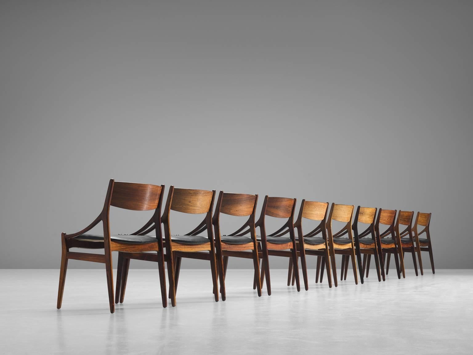 Set of ten dining chairs is designed by Vestervig Erikson, wood and black leather, manufactured and stamped by Brdr. Tromborg's Eftf, Møbelfabrik Vestervig Erikson Åarhus, Denmark, 1950s.

This Classic set of dining chairs features a sculptural