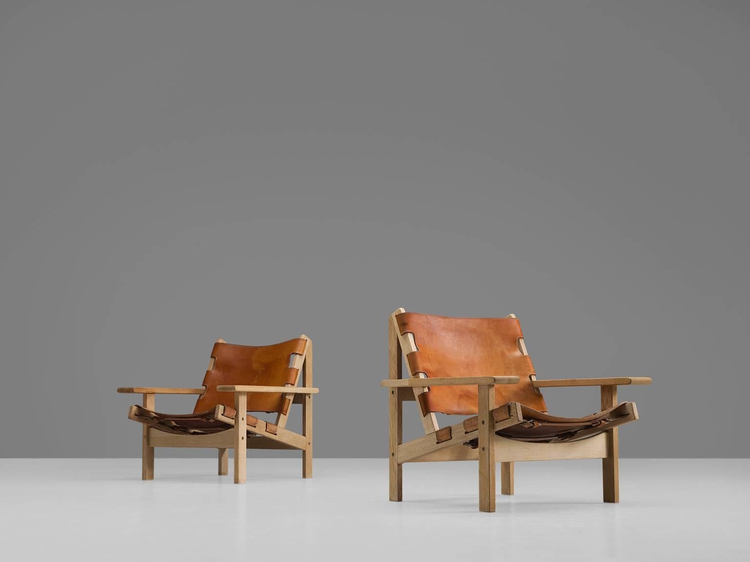 Erling Jessen, pair of lounge chairs model 168, solid oak, leather, Denmark, 1960s

This set shows exquisite Danish craftsmanship and aesthetics. The set features traits of hunting and a cabin lodge style. The slightly tilted back and result in a