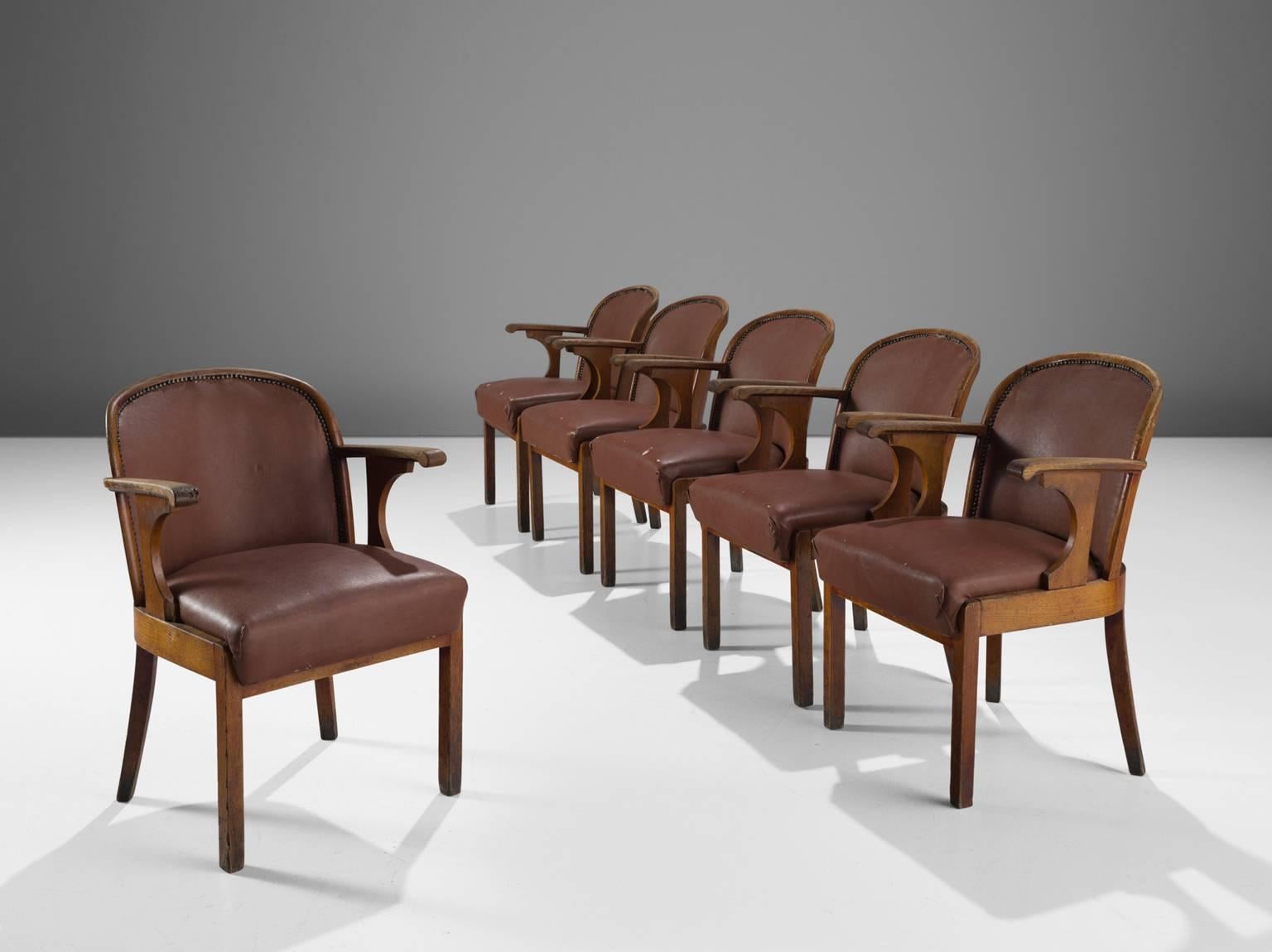Set of six chairs, in oak and brown faux leather, Sweden, 1940s. 

This set of six dining chairs with original leather upholstery is made by a Swedish cabinetmaker. The chairs have a solid oak frame, tapered legs, of which the back ones are slightly