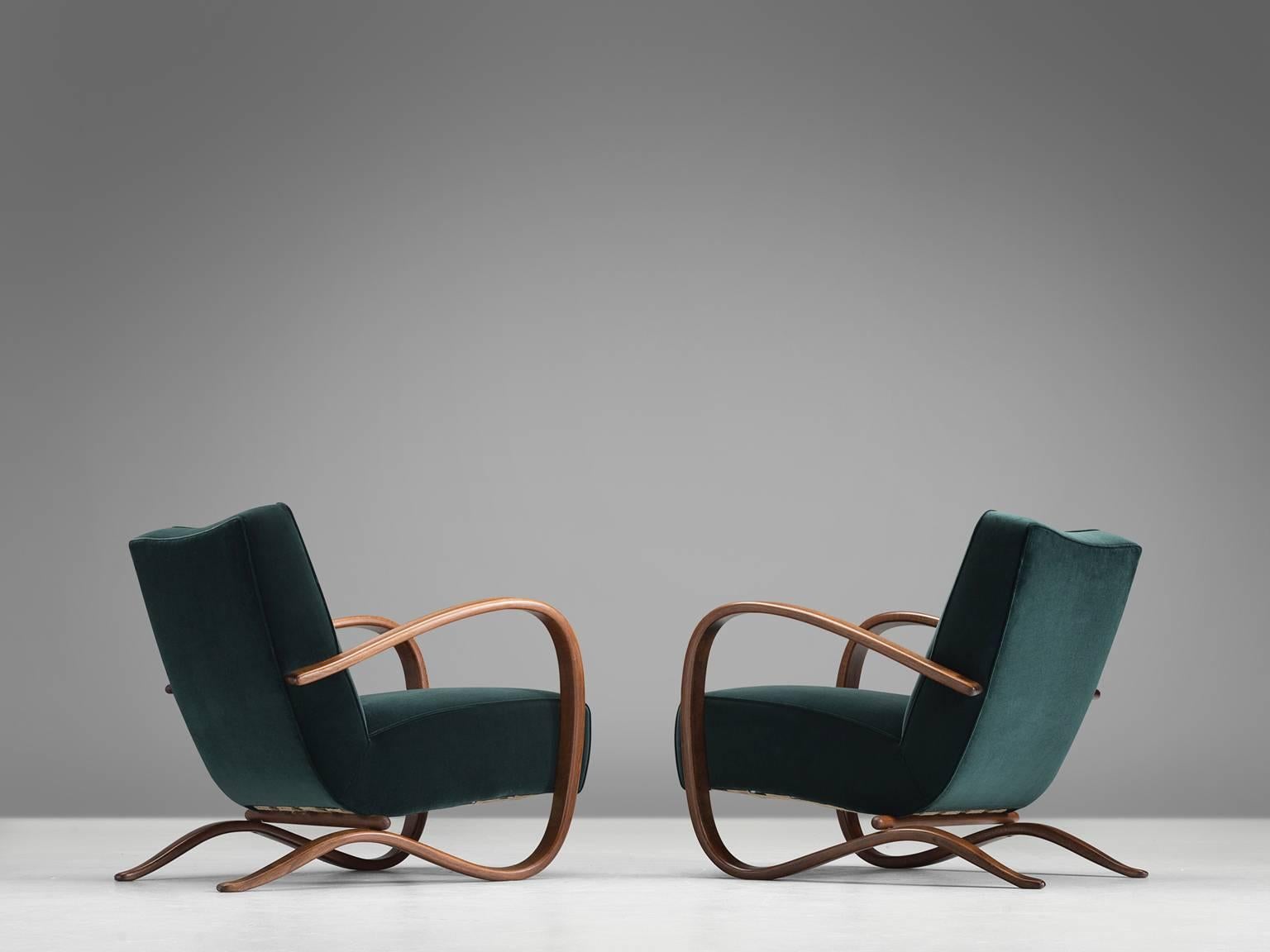 Set of two lounge chairs, in deep green velvet and stained beech, by Jindrich Halabala, Czech Republic, 1930s. 

Extraordinary pair of easy chairs with dark green velours upholstery. These chairs have a very dynamic appearance. This dreamy