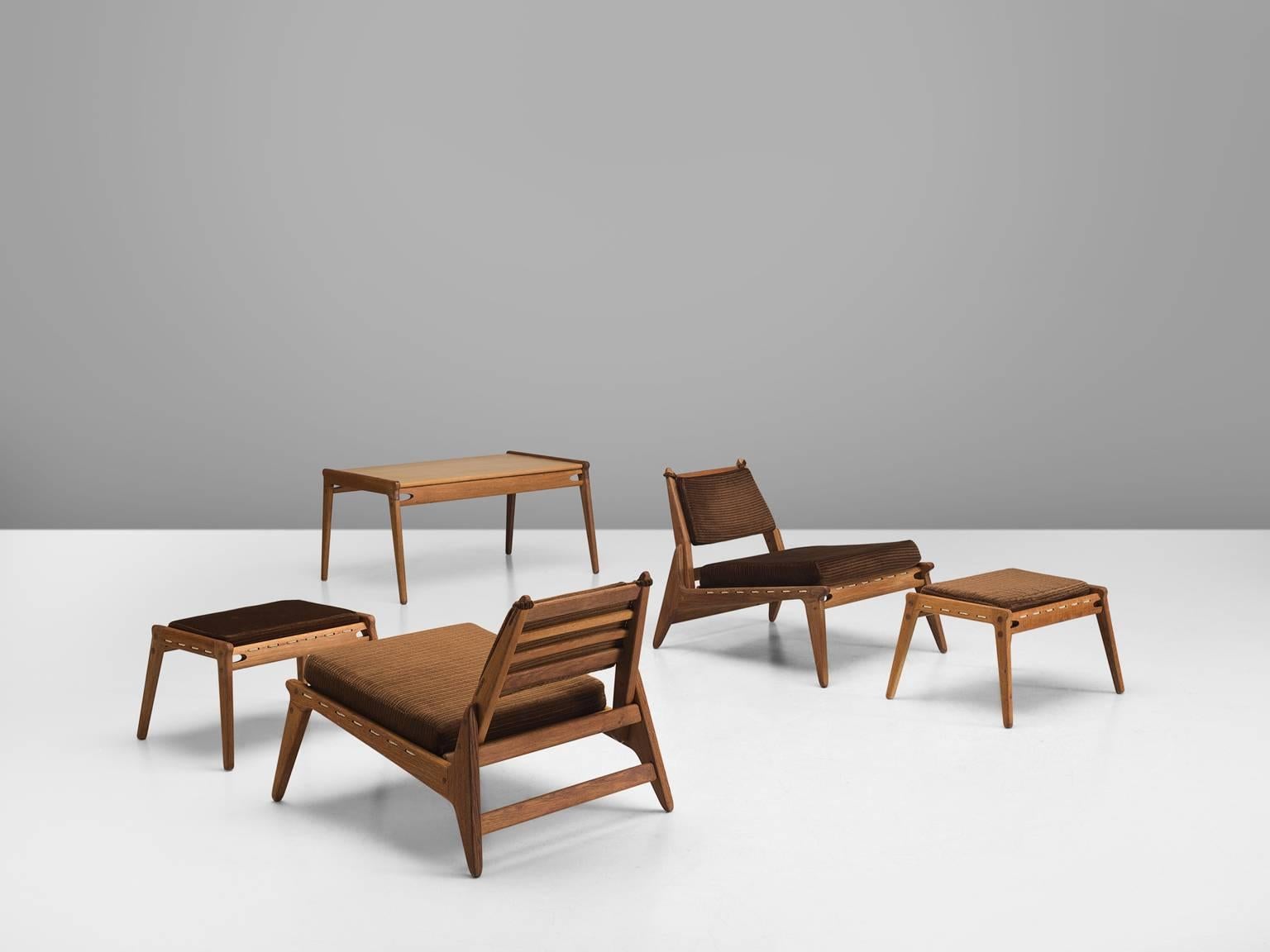 Pair of lounge chairs, ottomans and table in oak and fabric, Germany, 1950s. 

Set of two modular chaise longues with accompanying table. These relaxing hunting chairs show a basic minimal design with great woodworking. A great open character is