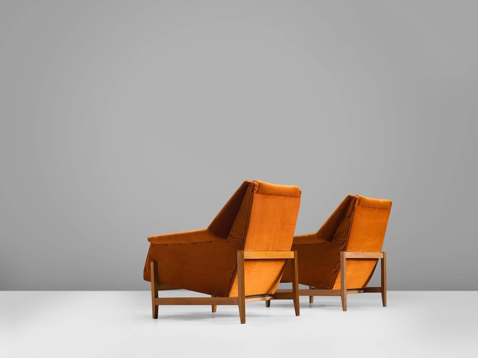 Set of armchairs, orange velours, wood, Italy, 1950s.

This set of lounge chairs is both comfortable and sculptural. The lines in this set are geometric and sharp with an angular frame that support the velvet, reclining shell. The chairs are wide