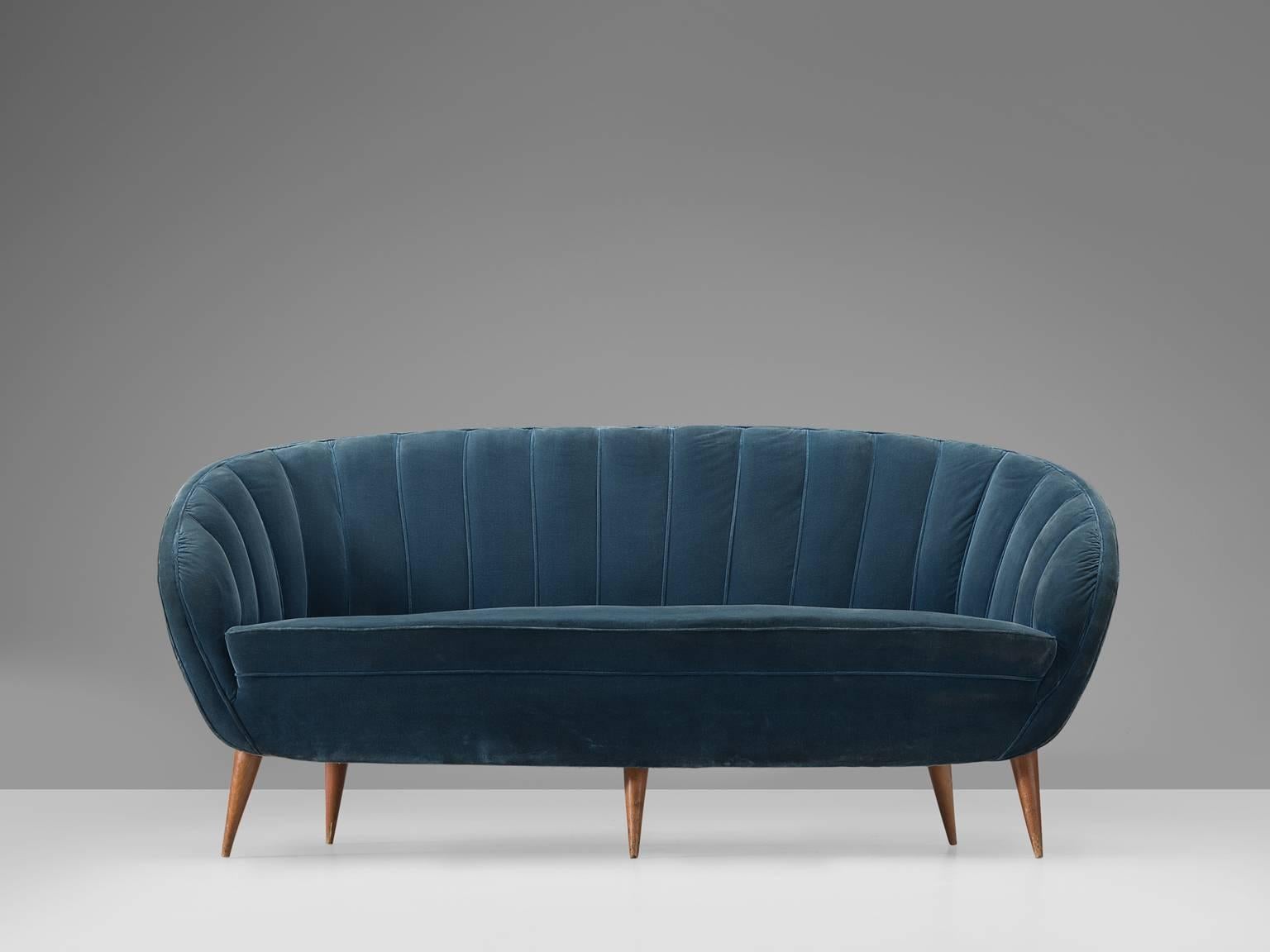 Settee, presumably by ISA, blue velvet and oak, Italy, 1950s. 

This ornate, cute but grand sofa is strong and playful at the same time. The webbed back gives perfect support for the sitter. The delicate oak legs support the voluptuous seat, which