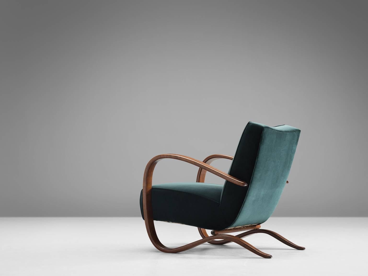 Lounge chair, deep green Kvadrat velvet and stained beech, by Jindrich Halabala, Czech Republic, 1930s. 

Extraordinary easy chair with dark green velours upholstery. This chair has a very dynamic appearance. This dreamy upholstery gives this