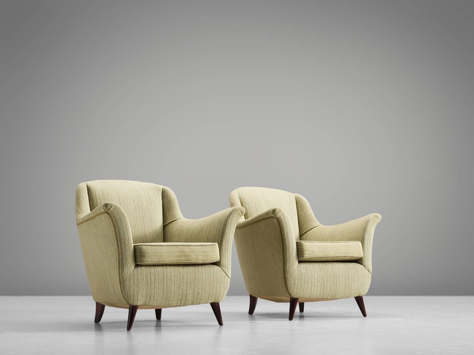 Set of armchairs, green fabric, wood, Italy, 1950s.

This set of lounge chairs is both voluptuous and grand as they are comfortable. The chairs have semi high wingbacks and feature green fabric and small tapered wooden legs. Typical curvy, bold