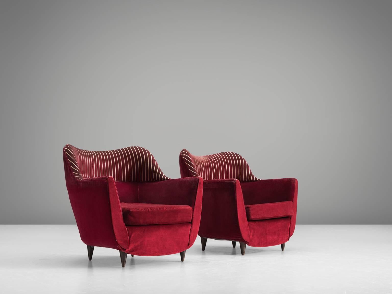 Set of armchairs, red fabric, wood, Italy, 1950s.

This set of lounge chairs is both voluptuous and grand as they are comfortable. The chairs have semi high wingbacks and feature deep red upholstery with golden vertical stripes on the top and small
