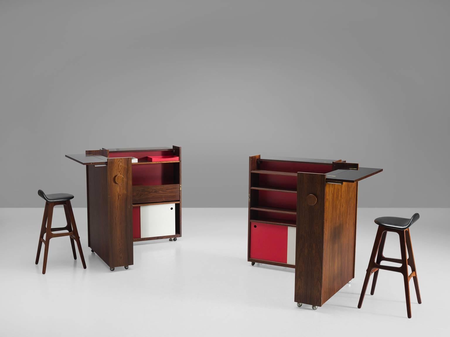 Two bar cabinets in rosewood and plywood, by Erik Buck, Denmark, 1960s. 

This set of Danish foldable rosewood dry bars are designed by Eric Buck. The bar features red and white elements on the inside whereas the outside of the bar is made from