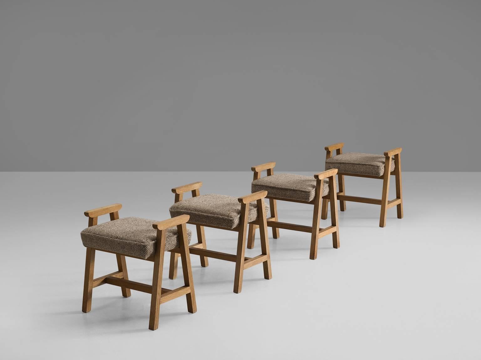 Set of four stools, in oak and fabric by Guillerme et Chambron, France, 1960s. 

This quartet of solid oak wooden stools with the neutral colours grey to beige, French designer duo Guillerme and Chambron. These stools have a frame in oak with