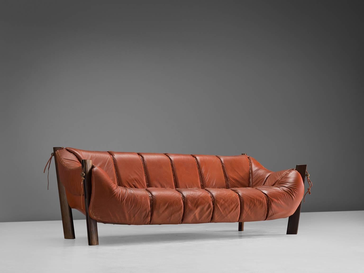 Percival Lafer, sofa model MP-211, in wood and leather, Brazil, 1974.

Three-seat sofa by Brazilian designer Percival Lafer. This sofa consist of a solid dark wooden base in which the leather seating 'hangs'. Soft cushions are folded over the wooden