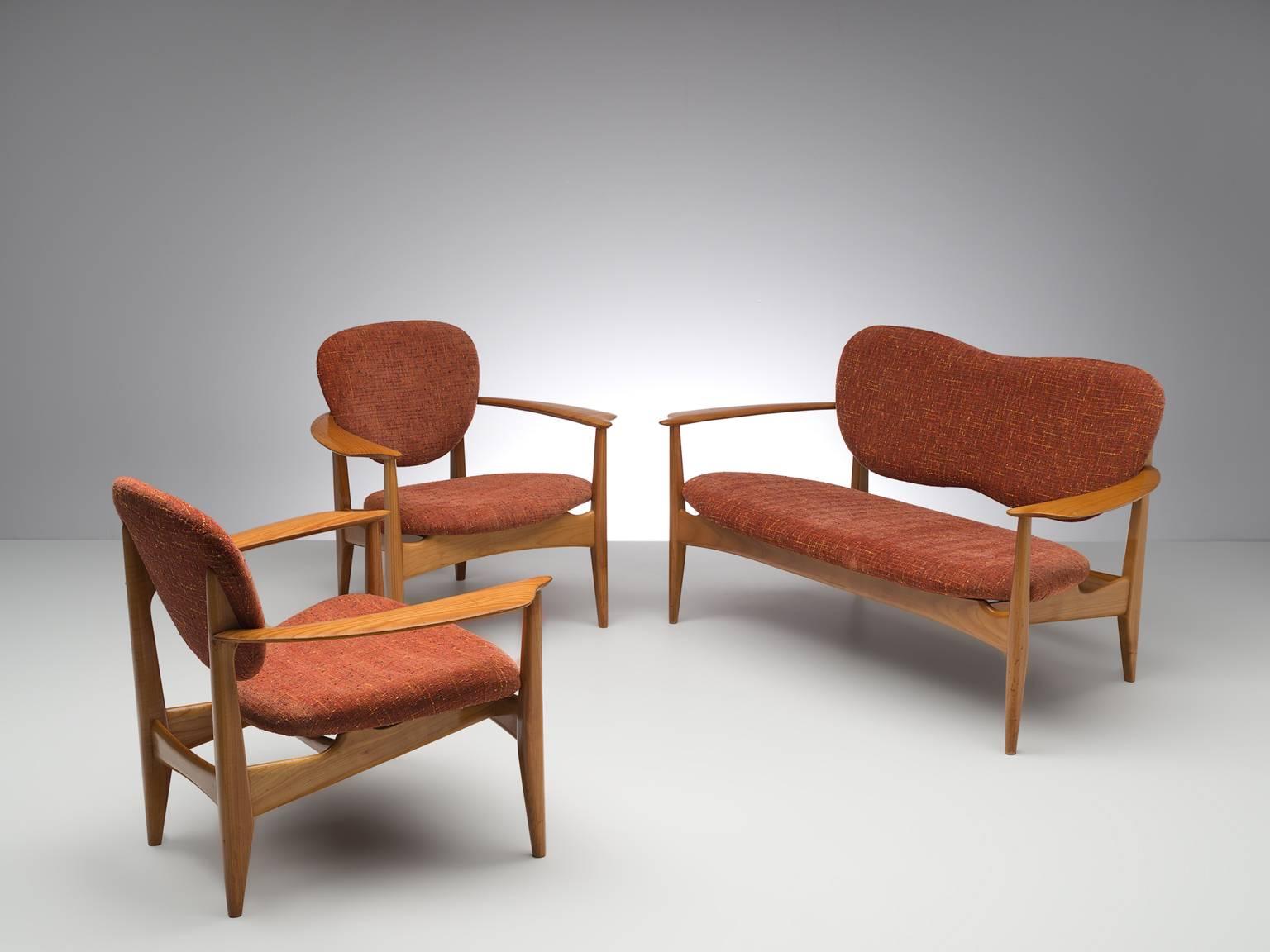Living room set, red to orange fabric, oak, Denmark, 1950s.

Wonderful delicate set consisting of two chairs and one sofa. These elegant, curved armchairs and sofa feature waved, butterfly backs and four tapered wooden legs. The chairs and sofa are