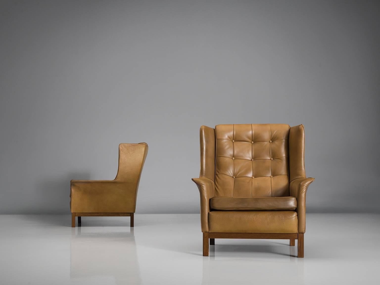 Highback chairs, in leather and wood, by Arne Norell, Sweden, 1960s. 

Wonderful pair of comfortable buffalo leather easy chairs by Swedish designer Arne Norell. These lounge chairs come with a very high standard of comfort, something that Norell