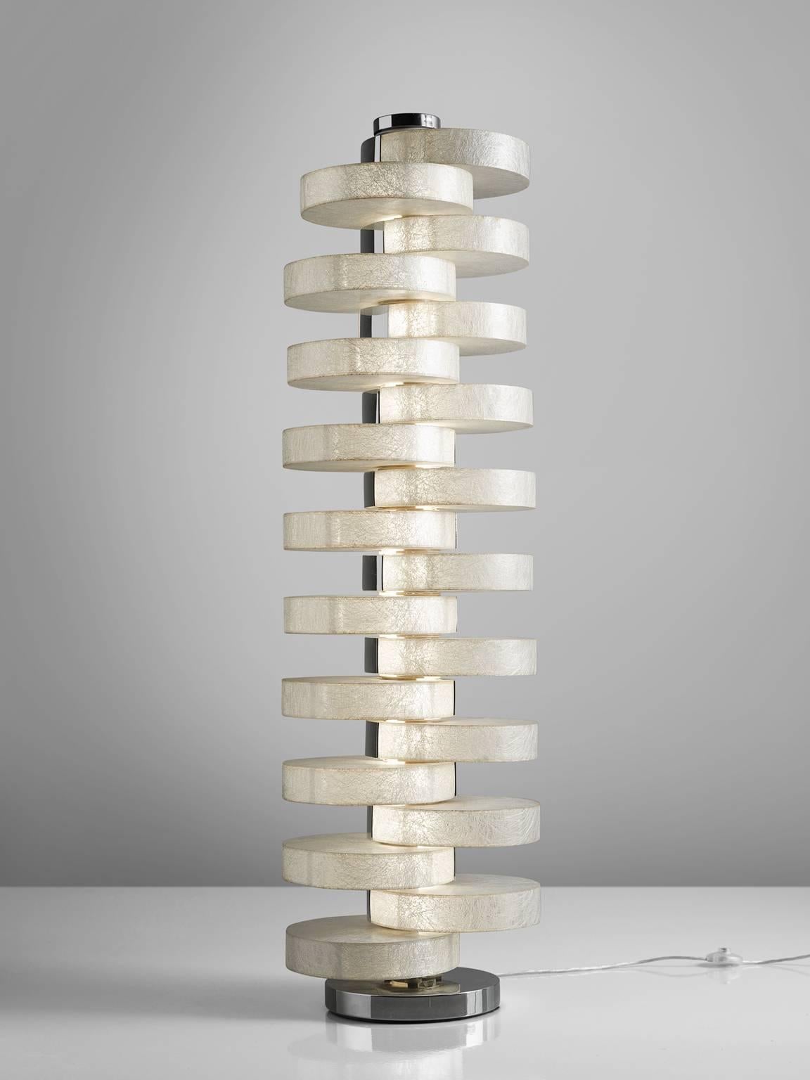 Floor lamp, fiberglass, metal, Italy, 1970s.

This floor lamp holds twenty, thick circular fiberglas circles that are stacked on top of one another. The circles are only stacked on the sides by means of which a very playful pattern is created. The