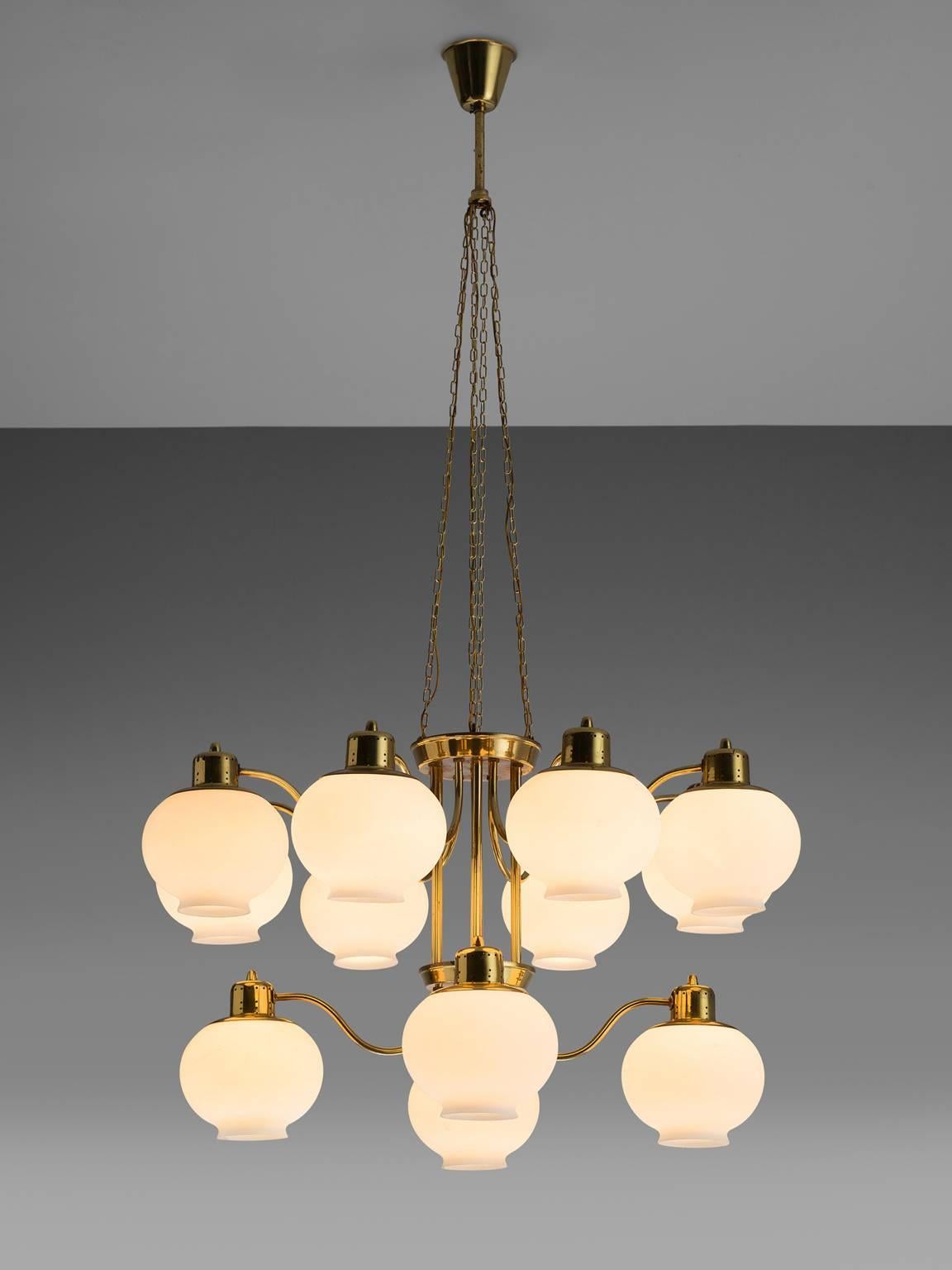 Hans-Agne Jakobsson, chandelier, brass and glass, Sweden. 

 The chandelier is produced by Hans-Agne Jakobsson AB in Markaryd, Sweden. The lamp seems to resemble the like of a plant as the brass branches outwards towards the glass shades. The